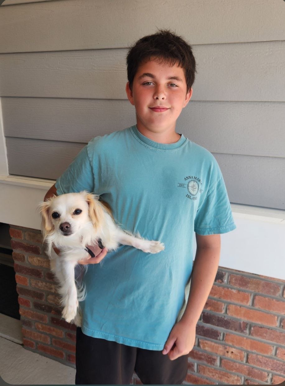 Vincent Bogucki, founder of Avalon Paws, holding a happy dog